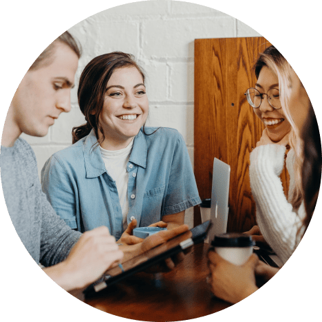 Four people having a meeting around a table.